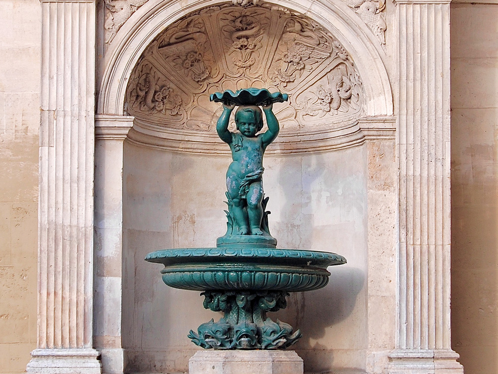 Les secrets de la fontaine Charlemagne de l'enfant portant une coquille